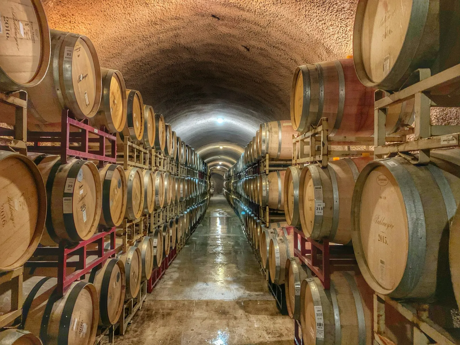 Barris de carvalho empilhados ao longo de um túnel-adega de vinícola em Calistoga, no Napa Valley
